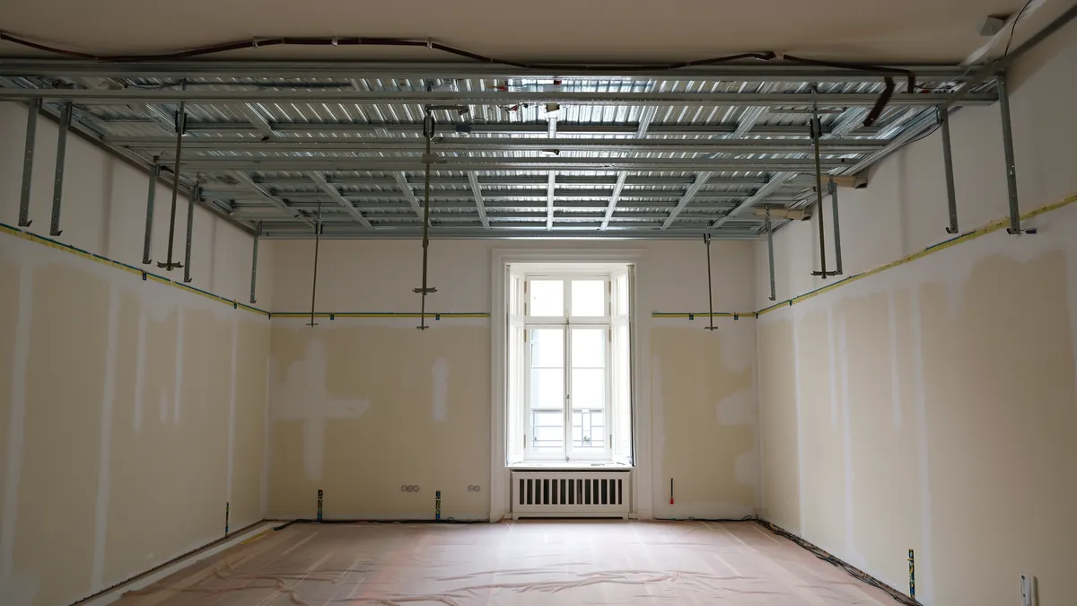 Metall-Unterkonstruktion einer abgehängten Decke vor der Beplankung in einem Altbau-Zimmer.